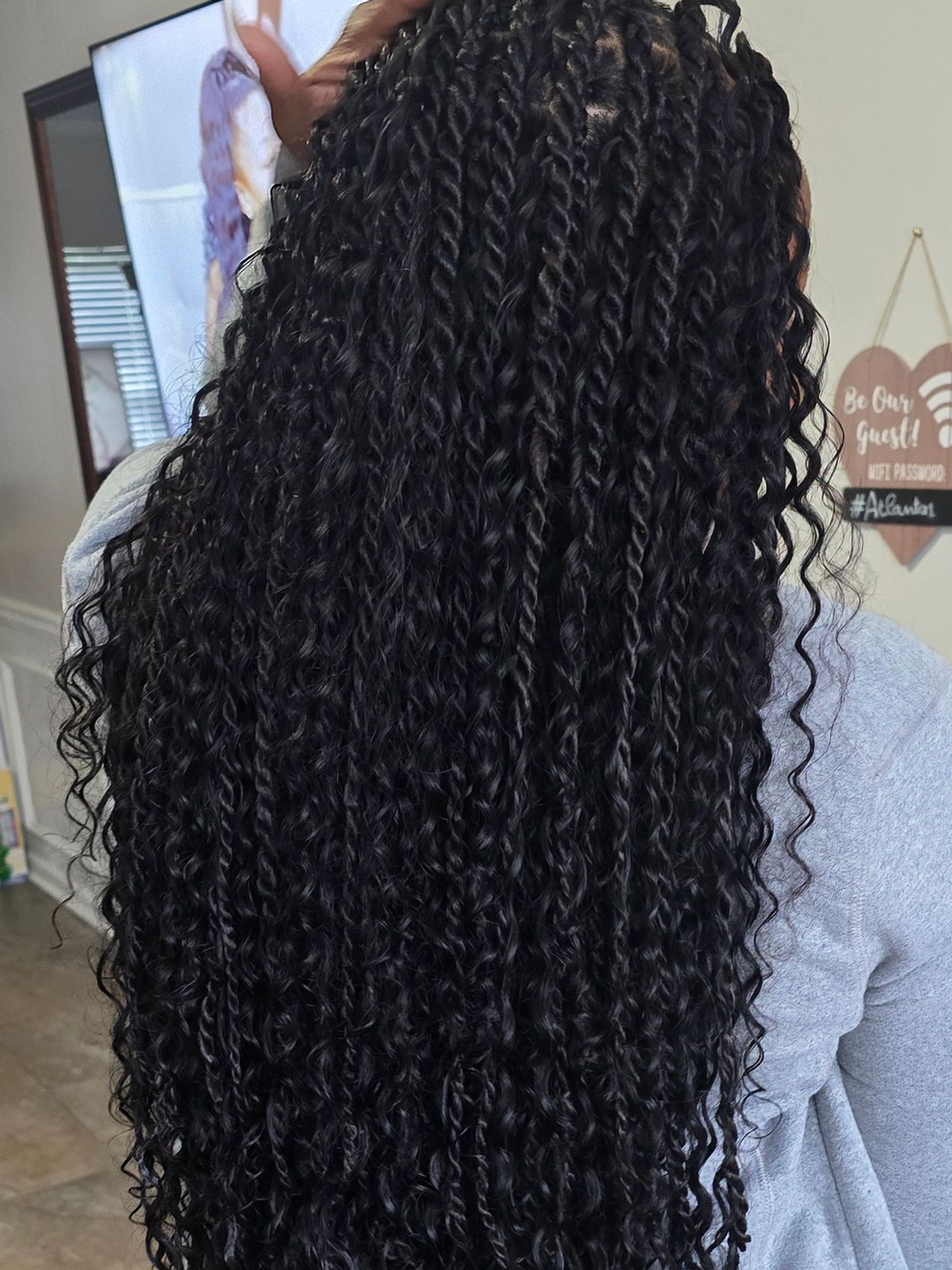 Long, curly black hair styled in twists.