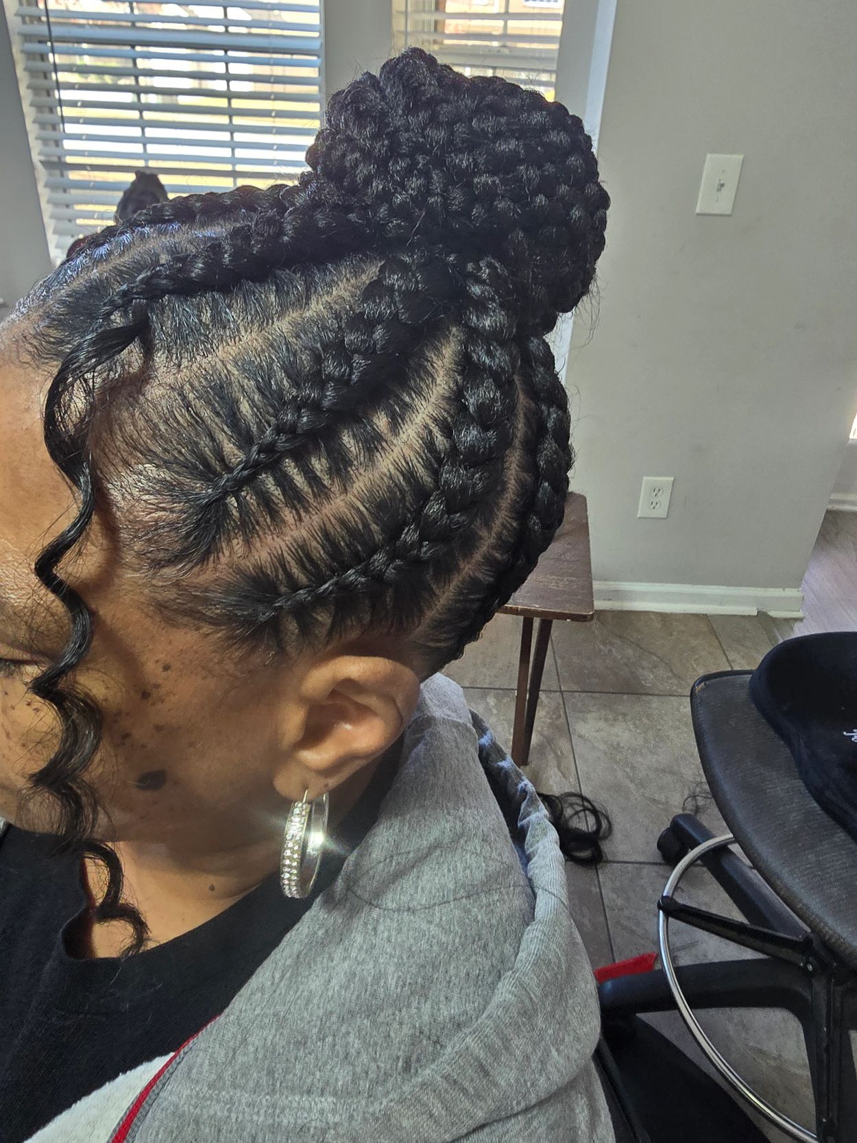 Intricate braided hairstyle tied into a neat bun.