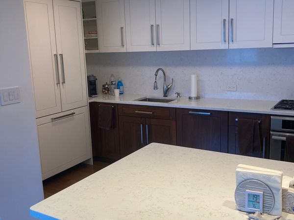 Upper West Side custom walnut and white lacquer kitchen. With paneled subzero fridge and quartz coun