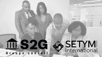 Des professionnels en apprentissage devant l'écran avec les logos de S2G et SETYM International.
