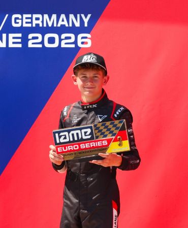 Young kart racer holding IAME Euro Series award.