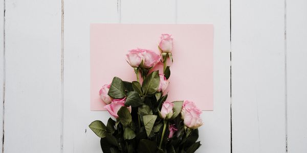 Pink envelope and flowers on a table