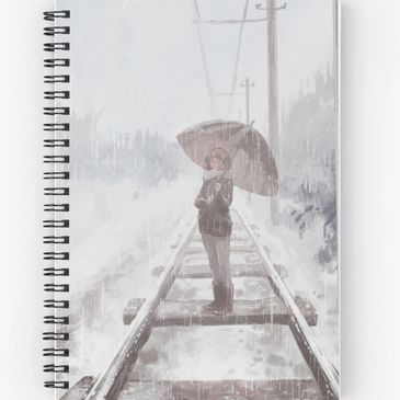 A picture of a notebook with a spiral and an illustration of a girl on train tracks in rain on it.