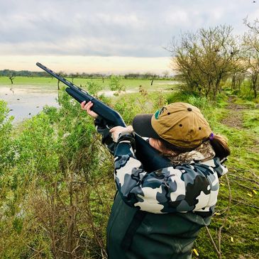 Hunter with gun aiming at the sky.