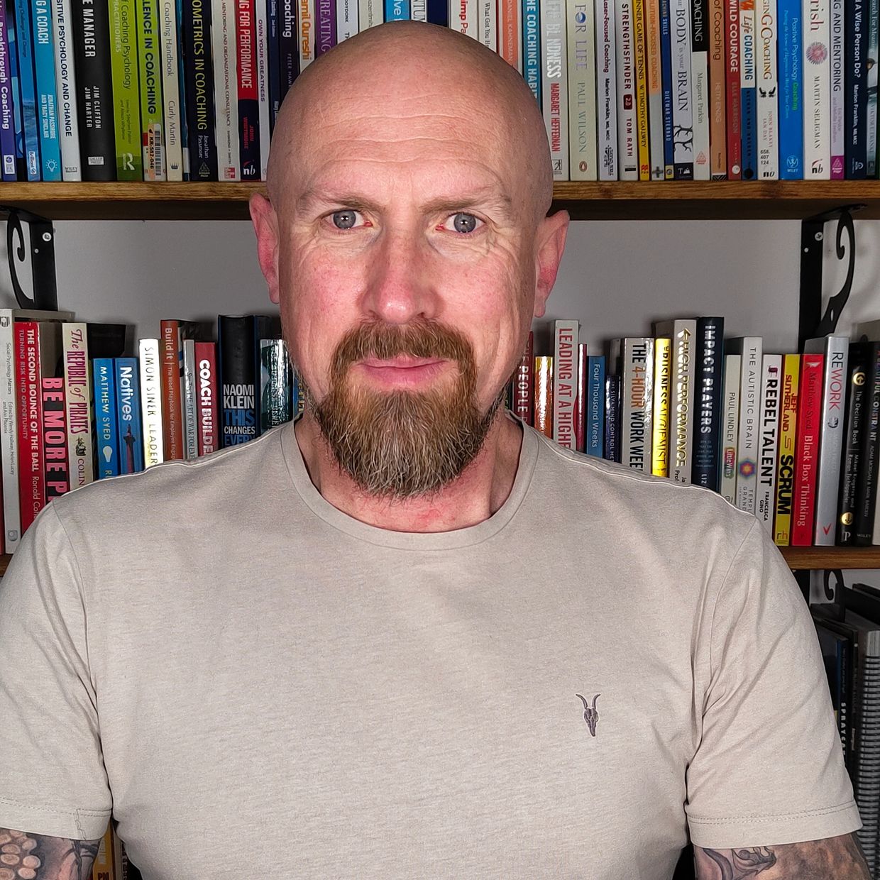 Steve Barrett, sitting confidently in front of a wall of leadership and personal development books.