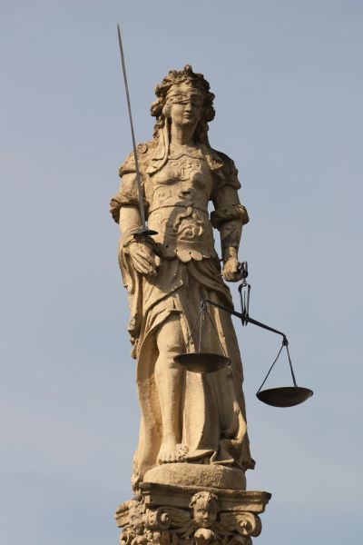 Beeld van gerechtigheid met blinddoek, zwaard en weegschaal.