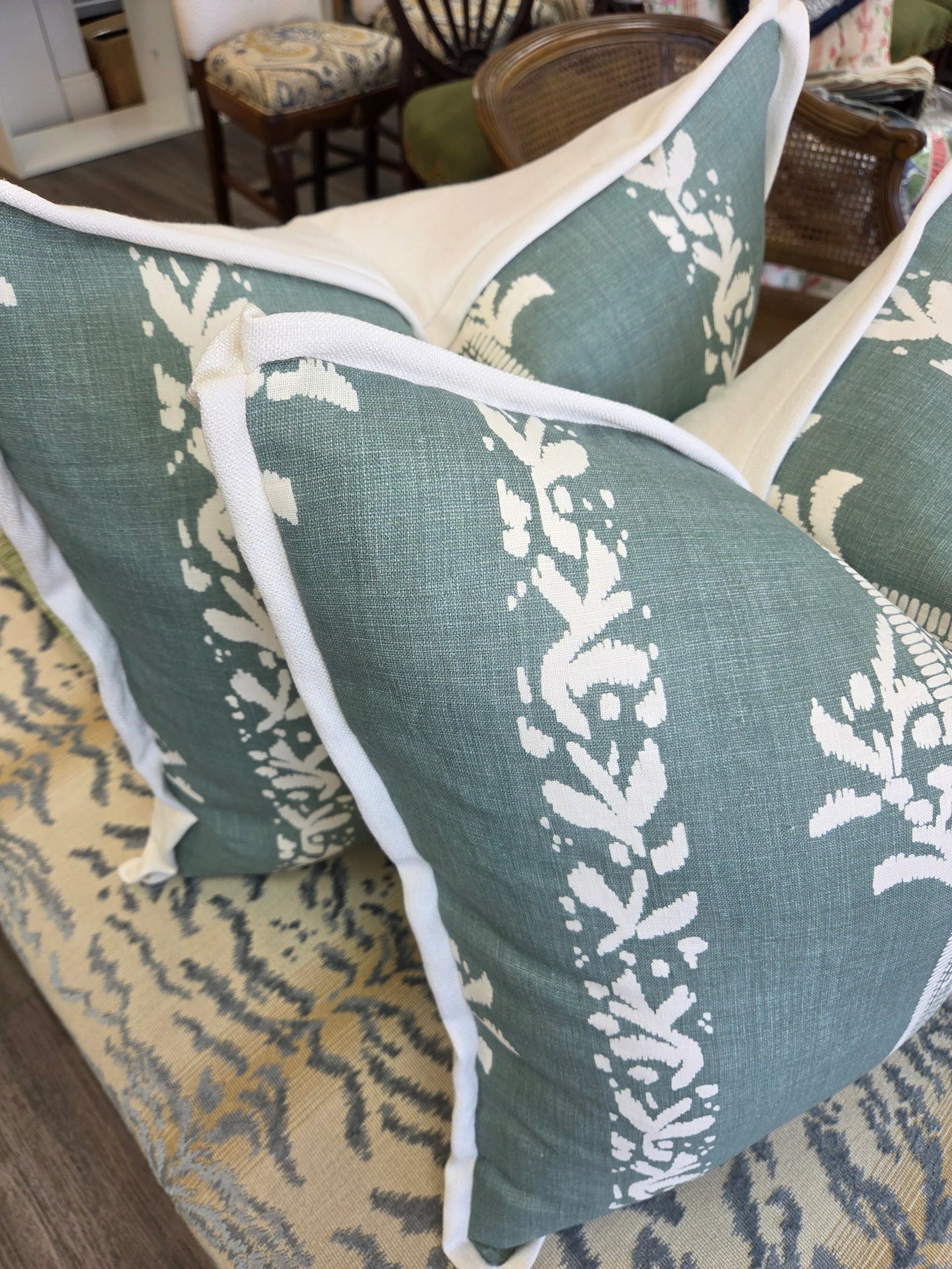 Blue and white patterned pillows on a floral rug.