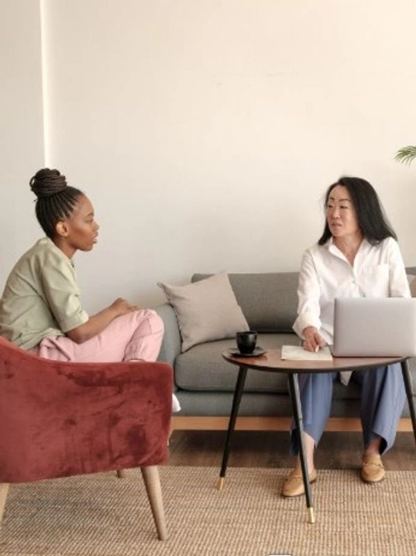 Two women engaged in a serious conversation in a cozy living room.
