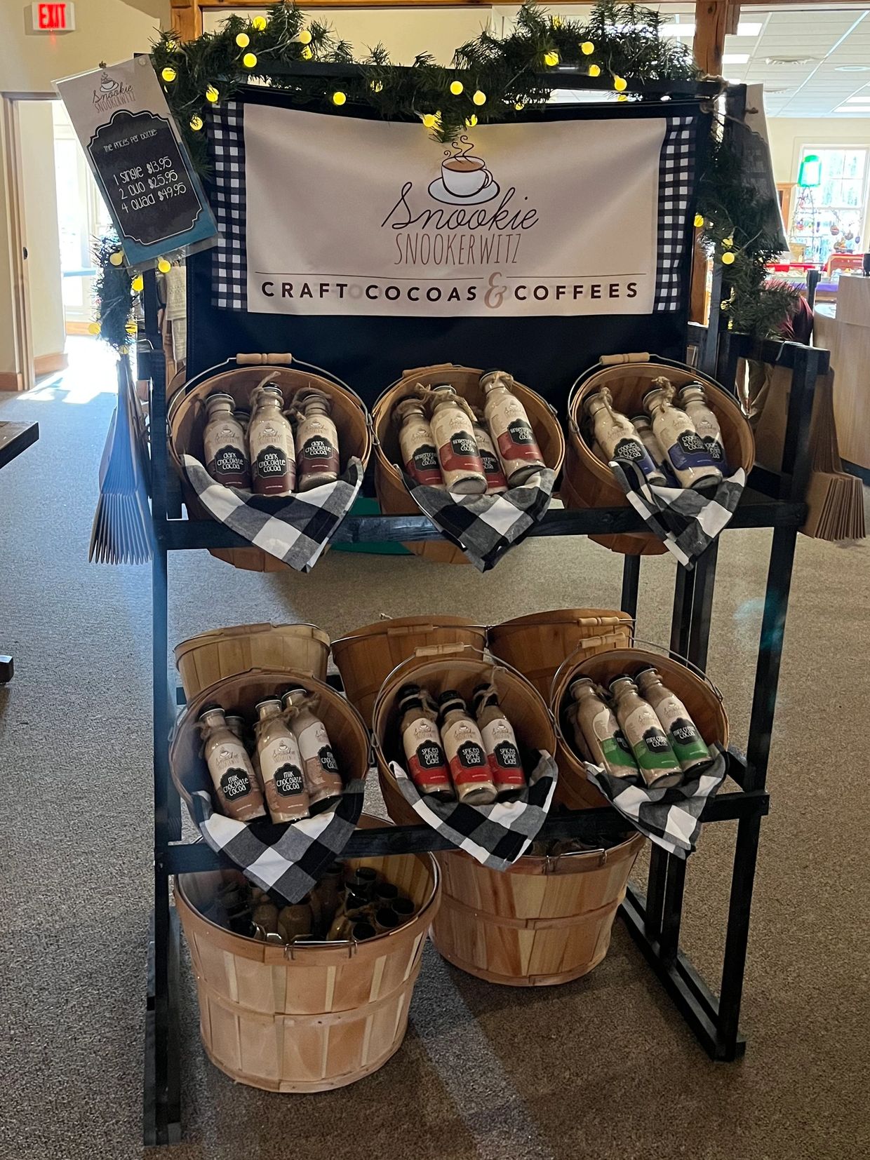 Display of bottled craft cocoas and coffees with festive lights.