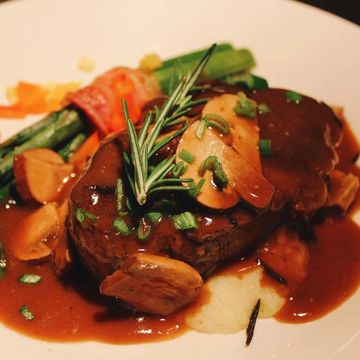 Steak with mushroom sauce and vegetables.