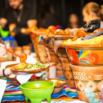 Colorful Mexican food serving pots at a vibrant food stall.