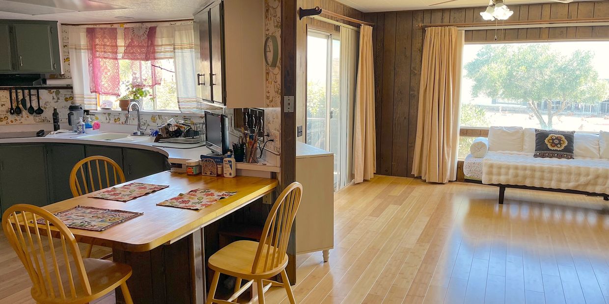 Cozy kitchen and living area with wooden furniture and bright natural light.