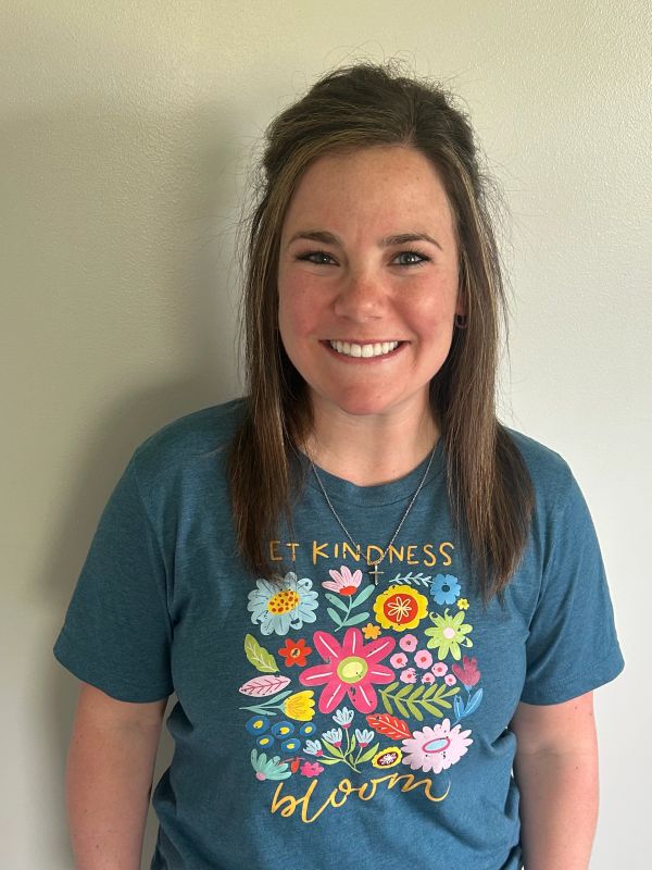 Smiling woman wearing a colorful floral shirt.