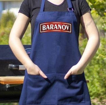 Person wearing a blue apron with 'BARANOV' logo outdoors.