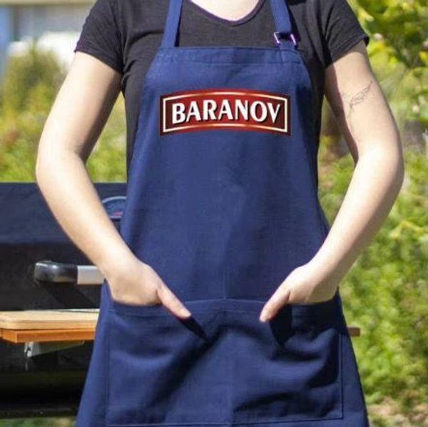 Person wearing a blue apron with 'BARANOV' logo outdoors.