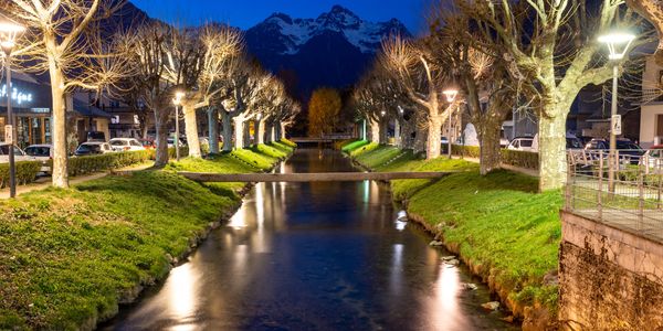 Night time view of a calm stream with mountains in the background
