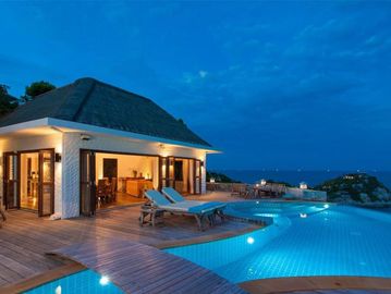Luxury villa with pool and ocean view at twilight.