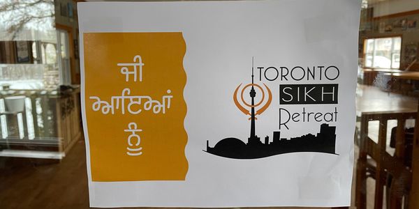 Sign for Toronto Sikh Retreat with skyline and Khanda symbol.