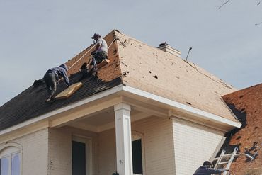 two roofers working on a house