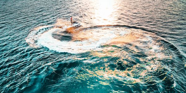 Person on a Jetski doing donuts in a circle on the river.