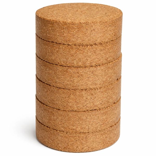 Stack of five round cork coasters on white background.