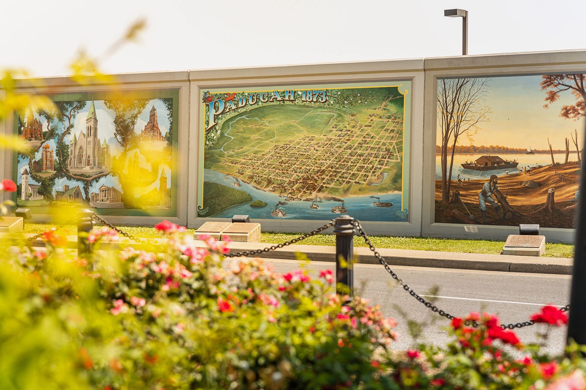 A colorful historical mural of Paducah from 1873 with flowers in the foreground.