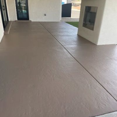 Clean concrete patio with fireplace and TV setup in a covered outdoor space.