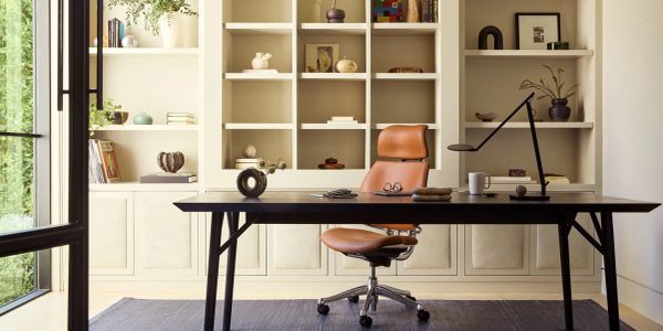 Minimalist office with a leather chair and organized shelves.