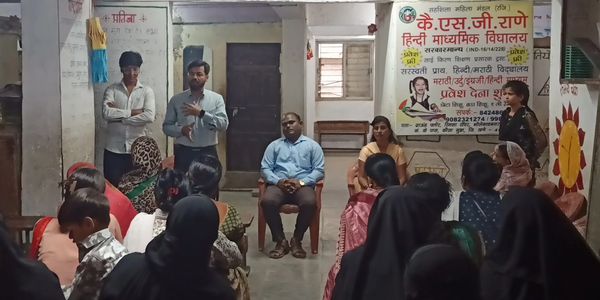 Community meeting at a local Hindi school with speakers addressing attendees.