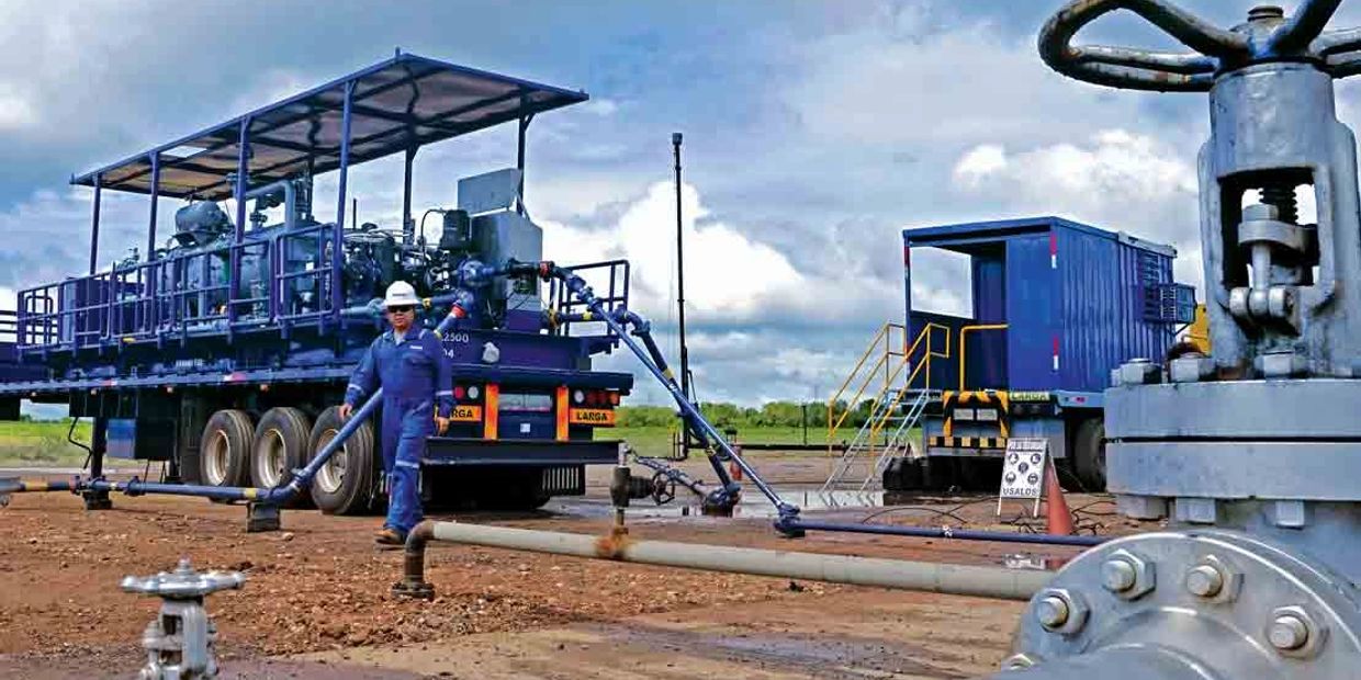 Trabajador en área industrial con maquinaria y tuberías.