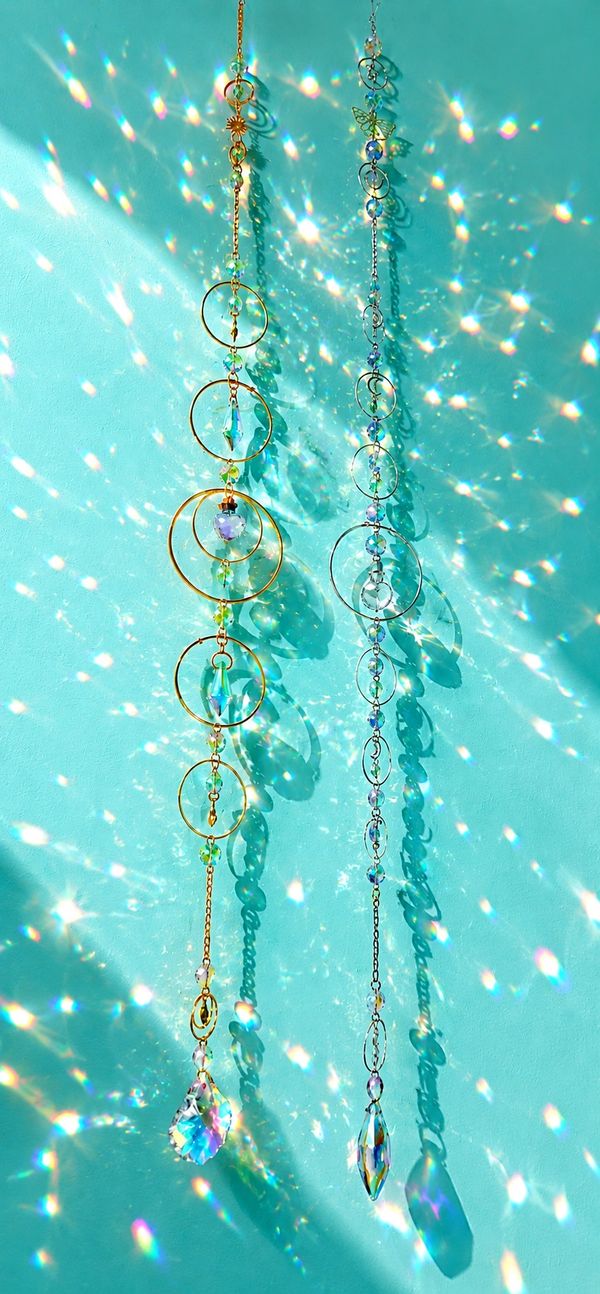 Two sparkling sun catchers with crystal prisms and golden rings casting colorful light.