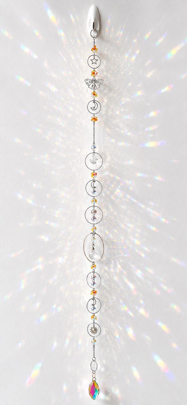 Decorative hanging ornament with celestial and nature motifs reflecting light.