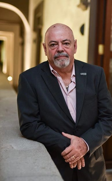 Hombre calvo con barba vestido formalmente.