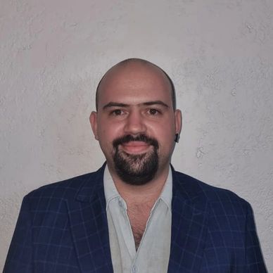 Hombre calvo con barba y bigote sonriendo.