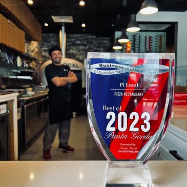 Award for Best Pizza Restaurant 2023 with chef in background.