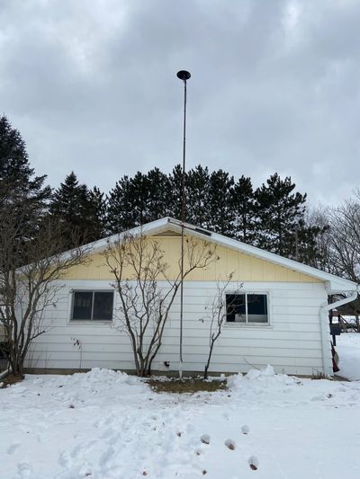 House with a tall pole and snow around it.