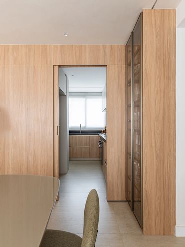 Painel em MDF com porta de correr para acesso a cozinha com cristaleira iluminada