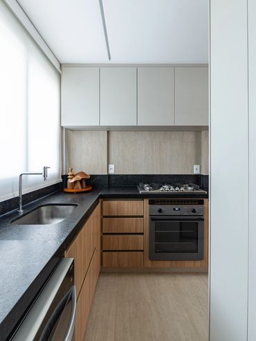 Cozinha e área de serviço integrada com bancada em Granito escovado e marcenaria sob medida