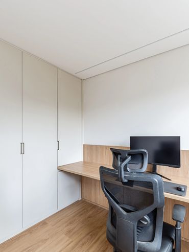 escritório com armário sob medida e bancada de trabalho com iluminação indireta 