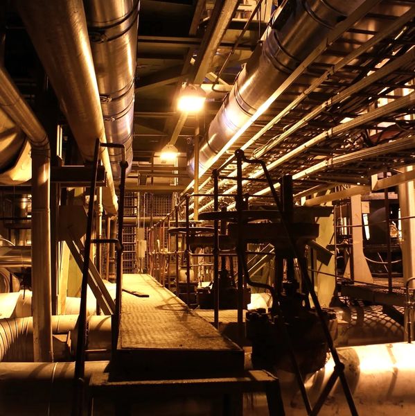 Industrial walkway with pipes and metal structures.