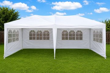 White outdoor event tent set up on grass.