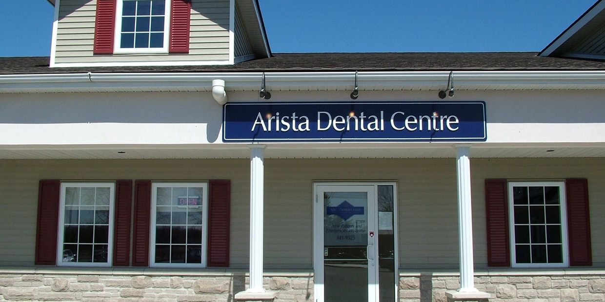 Exterior view of Arista Dental Centre with clear blue sky.