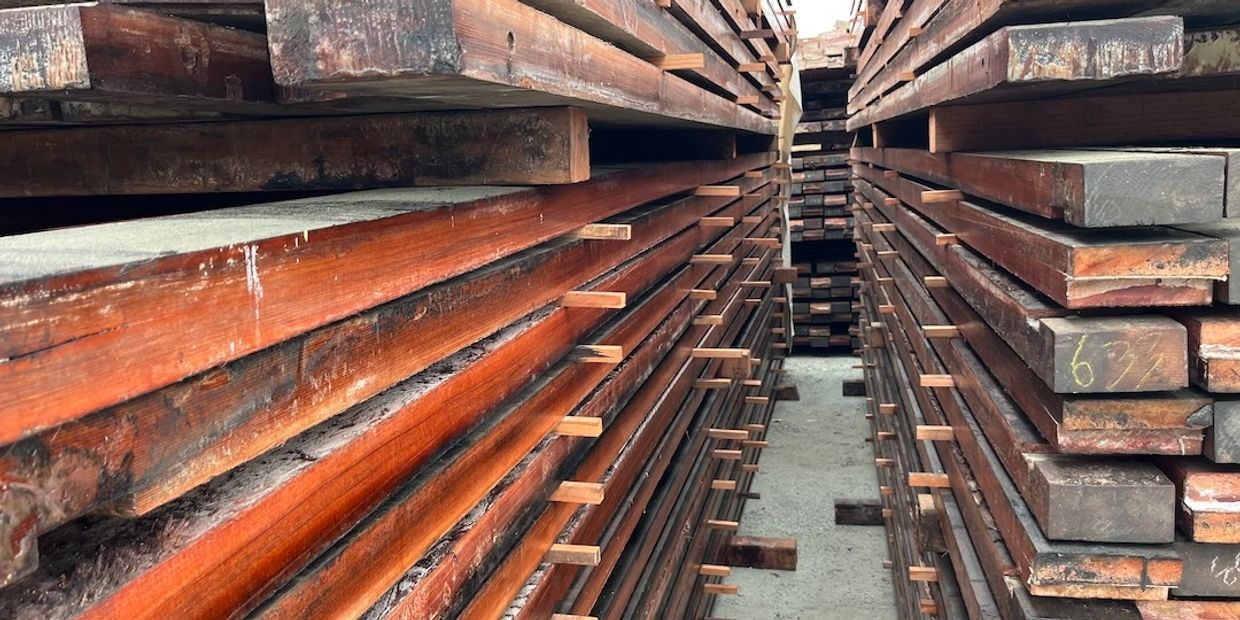 Stacks of wooden planks neatly arranged in rows.