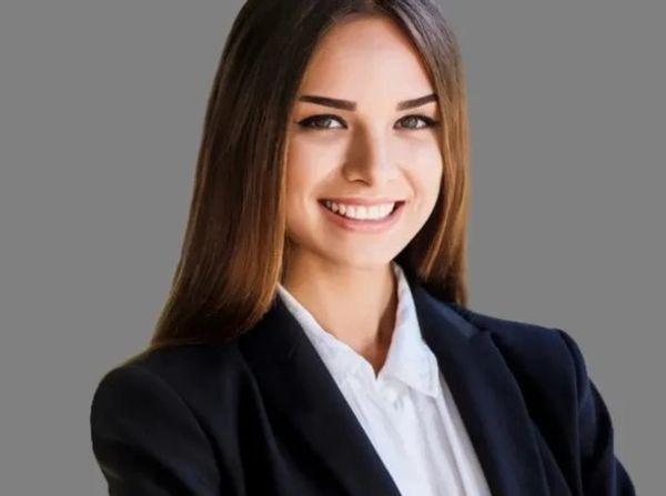 Professional young woman smiling confidently in business attire.