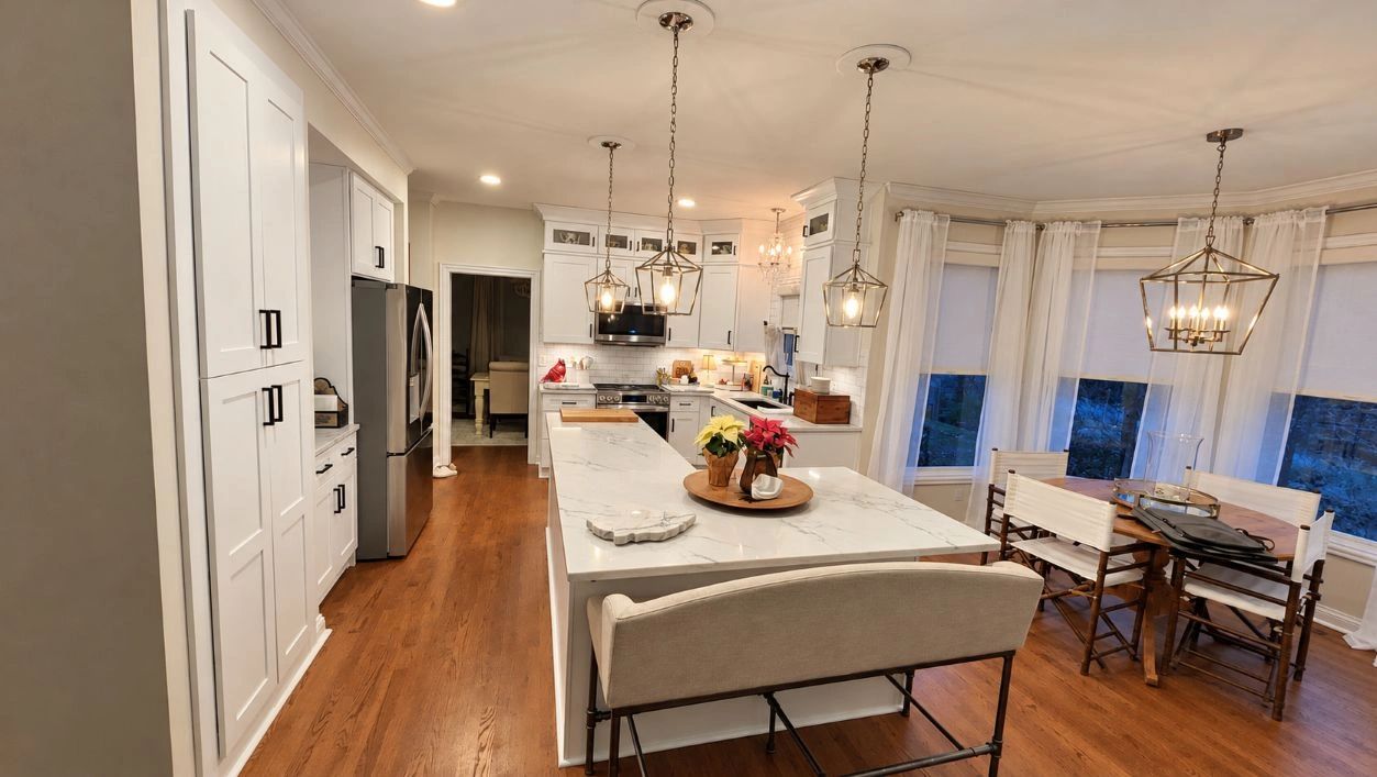 Modern kitchen with white cabinets and wooden floors.