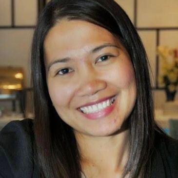Close-up of a smiling woman with long dark hair.