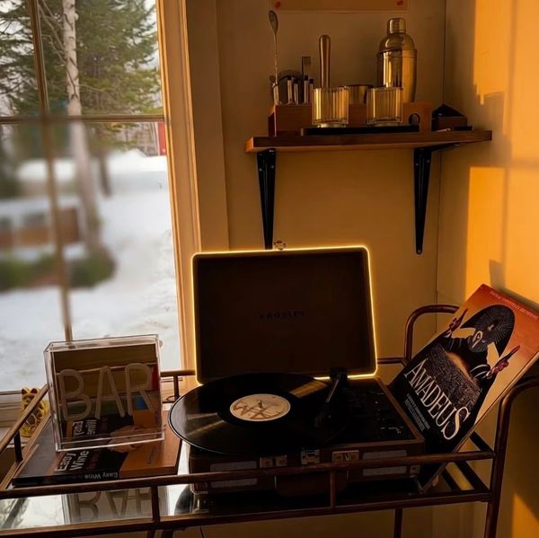 Vintage record player setup with Amadeus vinyl and bar accessories at sunset.