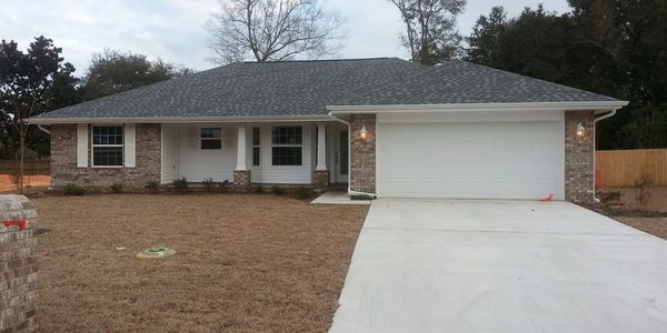 Single-story brick house with a two-car garage and a spacious driveway.