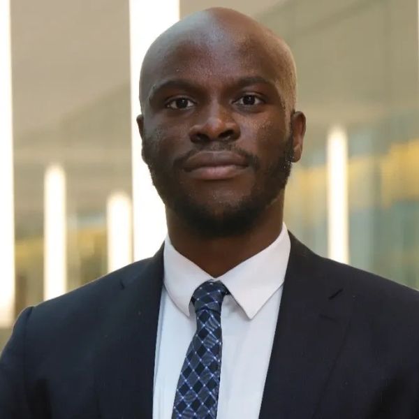 Confident man in a suit and tie posing indoors.