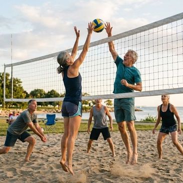 Seniors playing competitive beach volleyball on a sunny day.